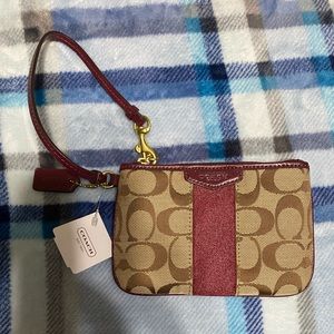 This is a never before used Khaki and Merlot Coach wristlet.